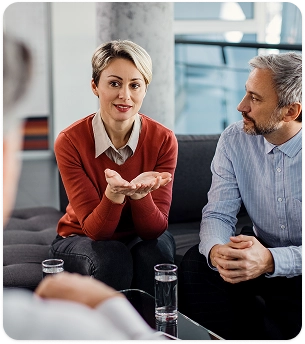 Man en vrouw in gesprek met een psychologisch adviseur tijdens een professionele consultatie in kantooromgeving